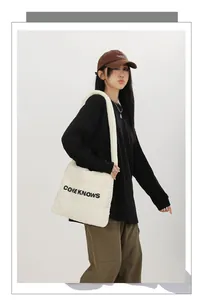 Mannequin portant un sac cabas en nylon matelassé crème avec un imprimé de lettres