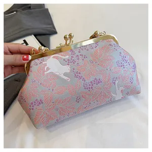 Close-up detail of the intricate cat and floral embroidery on this elegant evening clutch bag