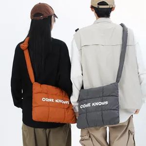 Vue de dos de modèles portant des sacs à bandoulière matelassés en nylon orange et gris.
