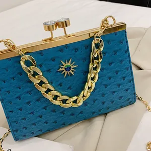 Λεπτομέρεια τσάντας clutch σε χρώμα πετρόλ με υφή στρουθοκαμήλου και χρυσό αστέρι