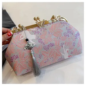 Elegant floral embroidered clutch bag featuring butterfly clasp decoration and grey tassel