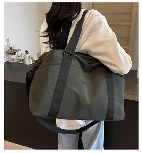 Olive green large travel duffel bag with luggage sleeve shown being carried by a model.