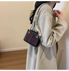 Stylish wool plaid square crossbody bag with gold chain strap worn by a chic model