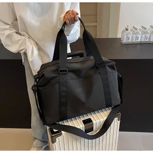 Large black travel duffel bag showing the trolley sleeve attached to luggage handle
