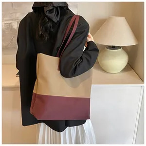 Λεπτομερής άποψη μιας ρετρό colorblock τσάντας tote που φοριέται στον ώμο μοντέλου