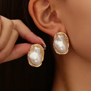 Elegant vintage irregular pearl stud earrings with a textured gold border finish
