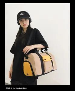 Sac de sport beige élégant de grande capacité porté par un modèle pour le voyage.