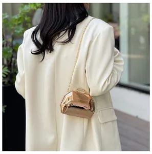 Elegante roségouden mini-avondtas met kettingriem getoond op een model in de outfit