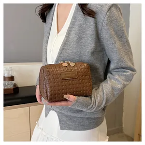 Elegant brown woven texture square makeup bag held by a model in a lifestyle setting