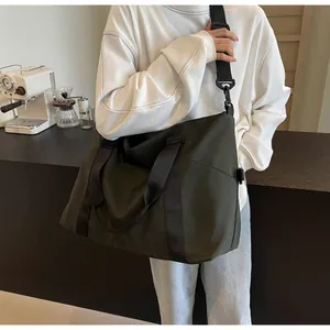 Detailed lifestyle view of large olive green travel duffel bag with black straps
