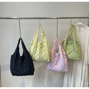 Stylish smocked pleated tote bags in various pastel colors displayed on a metal rack.