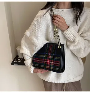 Close-up view of a stylish tartan woolen square bag featuring a gold chain strap