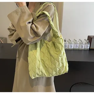 Detailed view of the unique pleated texture on a light green large capacity tote bag