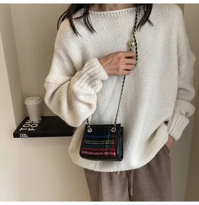 Detailed view of tartan woolen square crossbody bag featuring a golden chain strap