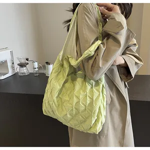 Detailed view of lime green pleated tote bag carried by model in casual setting