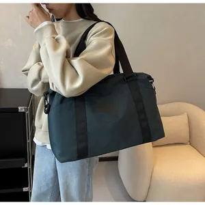 Large capacity travel tote bag with dry-wet separation being carried by a model.