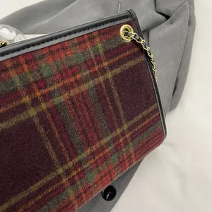 Close-up view showing texture of vintage plaid wool crossbody bag with gold chain