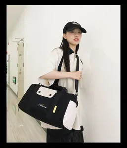 Mannequin asiatique portant un grand sac de voyage noir et blanc en couloir moderne