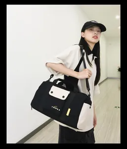Modèle portant un grand sac de sport noir et beige pour le fitness et les voyages