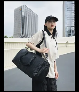Mannequin asiatique portant un grand sac de voyage tissé noir pour sport ou voyage