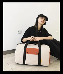 Modèle tenant un grand sac de sport beige pour le fitness, le voyage et le sport.