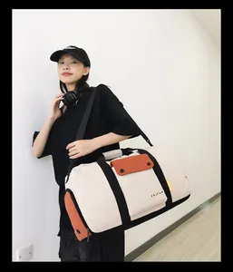 Sac de sport et de voyage de grande capacité beige et orange porté par un mannequin