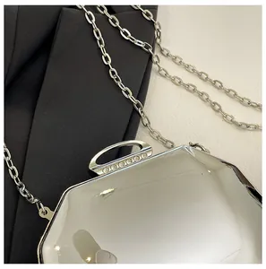 Detail van een elegante zilveren avondtas met strass-sluiting en lange kettingriem