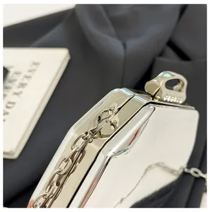 Detailopname van een zilveren metalen avondclutch met ketting en elegant sluitingsontwerp
