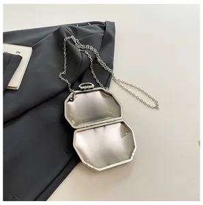 Gedetailleerd binnenaanzicht van een elegante zilveren achthoekige avondtas met ketting.