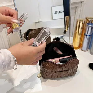 Detailed close-up of brown woven cosmetic bag with makeup accessories on white table