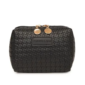 Close-up of black woven texture cosmetic pouch with gold-tone hardware