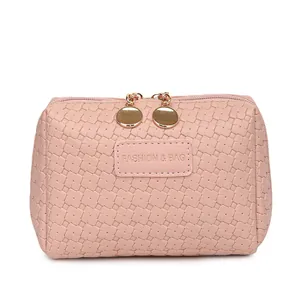 Pink woven texture cosmetic bag with elegant gold zipper pulls for stylish daily travel.