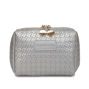 Silver woven pattern makeup bag with gold zippers and rectangular patch.