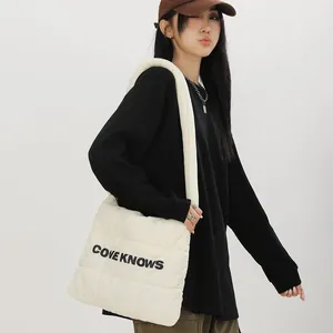 Vue détaillée du sac fourre-tout en nylon matelassé crème avec imprimé de lettres noires