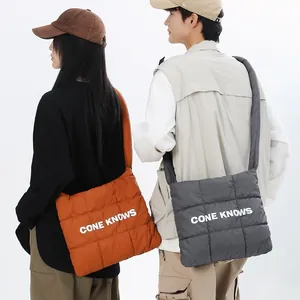Gros plan sur des sacs à bandoulière en nylon matelassé orange et gris avec lettrage