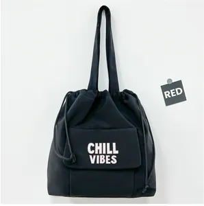 Detailweergave van de zwarte nylon tas met trekkoord en de witte Chill Vibes-tekst