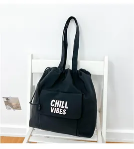 Minimalistische zwarte nylon tote bag met trekkoord en Chill Vibes tekst