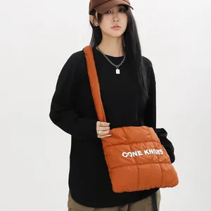Vue détaillée d'un sac cabas orange matelassé avec imprimé de lettres sur un mannequin