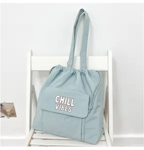 Gedetailleerd aanzicht van blauwe nylon shopper met trekkoord en CHILL VIBES print