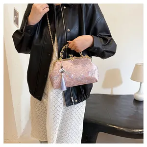 Close-up detail of a pink embroidered evening bag featuring gold clasp and tassel
