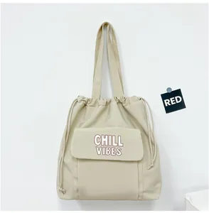 Vooraanzicht van een minimalistische beige nylon draagtas met Chill Vibes tekst