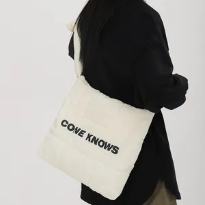 Vue détaillée d'un sac cabas matelassé crème avec l'imprimé de lettres CONE KNOWS