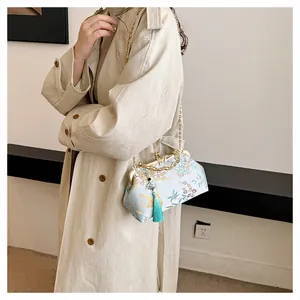 Elegant embroidered floral evening handbag with turquoise tassel and gold chain strap