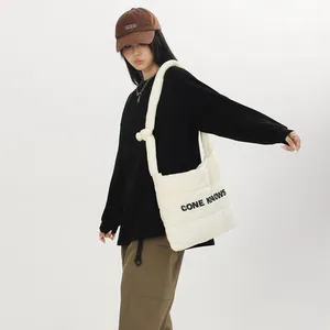 Détail d'un sac à bandoulière en nylon matelassé blanc avec imprimé de lettres