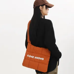 Sac à bandoulière matelassé orange avec imprimé CONE KNOWS porté par un modèle