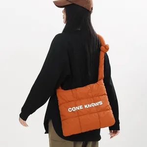 Vue détaillée du sac à bandoulière en nylon matelassé orange avec imprimé.