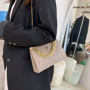 Elegante beige handtas met struisvogelpatroon en gouden ketting voor dagelijks gebruik.