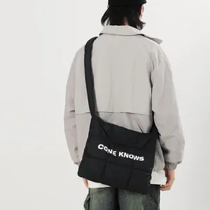 Vue de dos du mannequin portant un sac à bandoulière en nylon noir matelassé imprimé