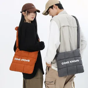 Sac à bandoulière matelassé en nylon avec impression de lettres blanches sur modèles.