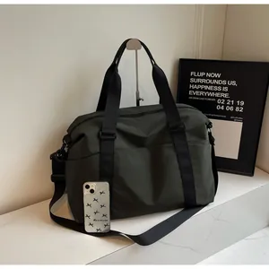 Dark green large capacity travel duffle bag shown with phone for scale comparison